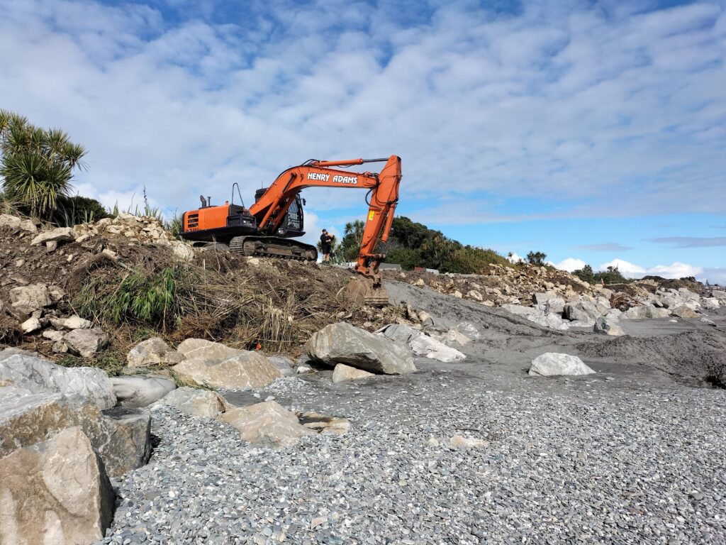 Digger repairing coastal rock protection - Hokitika